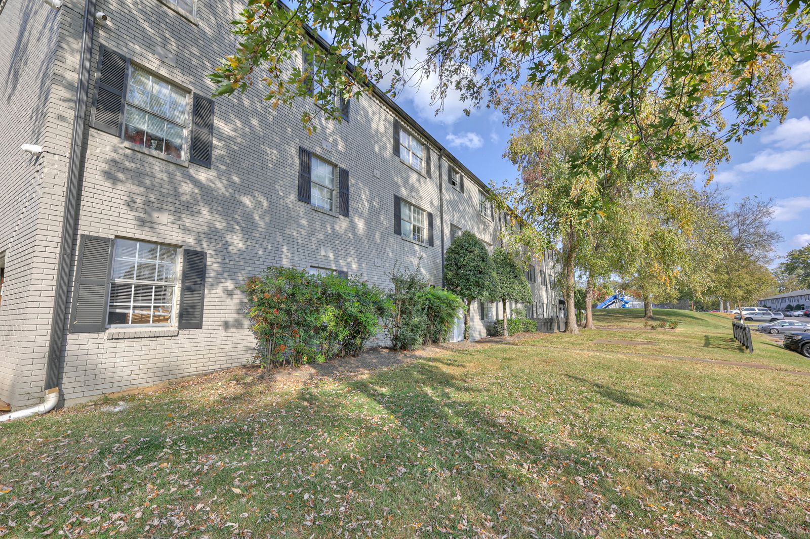 Photo of a three story building, showing a grassy area out front