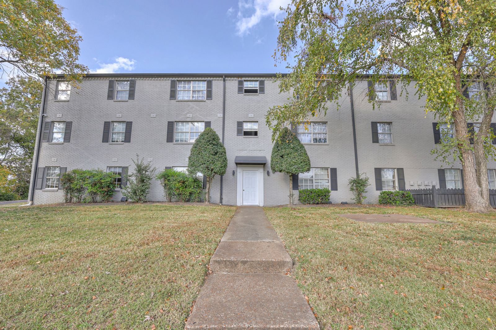 Photo of steps leading up to a three story building, with a grassy area in front