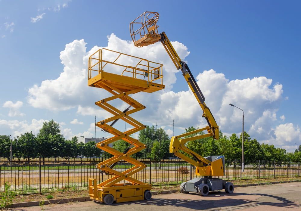 Yellow Scissor Lift and Articulated Boom Lift Against a Blue Sky With Clouds — Airlie Tree Specialists Pty Ltd in Bowen, QLD