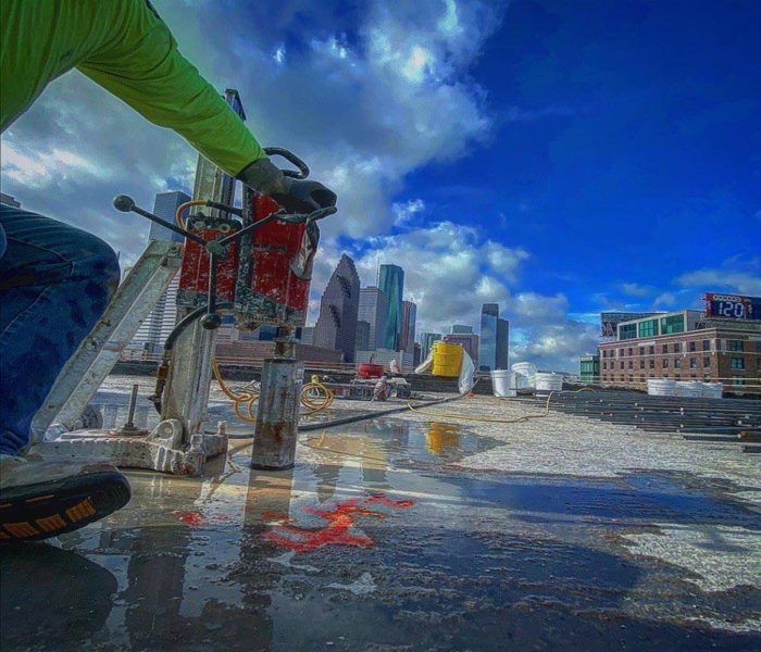 Cyclist rides on wet street with city skyline and dramatic blue sky in the background