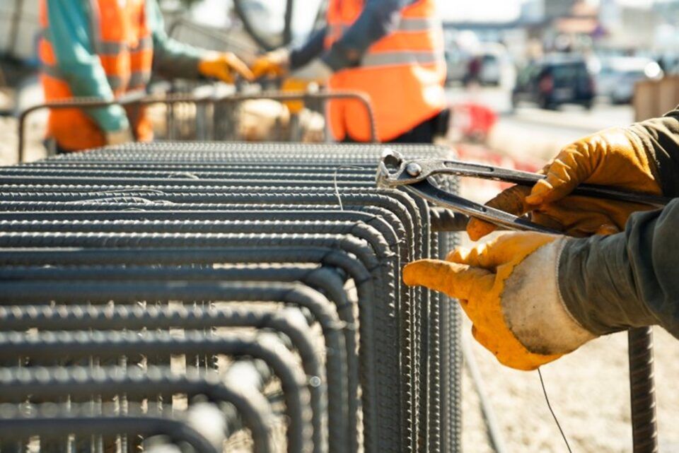 Team of construction workers erecting a steel fence in TX and LA