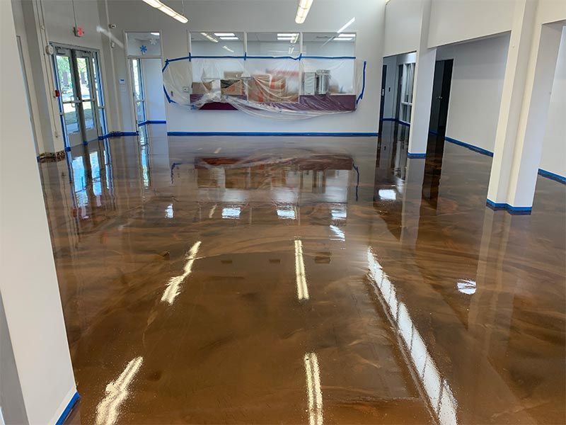 Empty hallway with glossy brown floor, white walls, and a mural on the far wall.