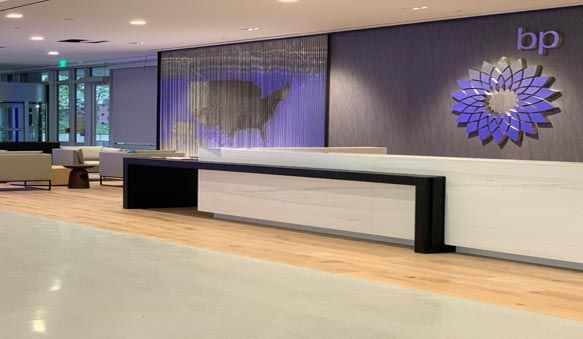 BP office lobby with reception desk, wood floor, and large wall logo
