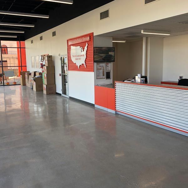 Modern office lobby with red-and-white reception desk, polished floor, and wall map display