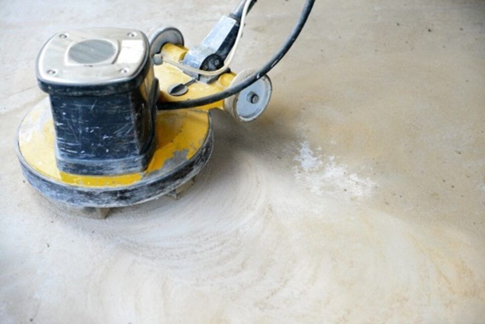 Floor buffer polishing a concrete floor, leaving a smooth, dusty swirl.