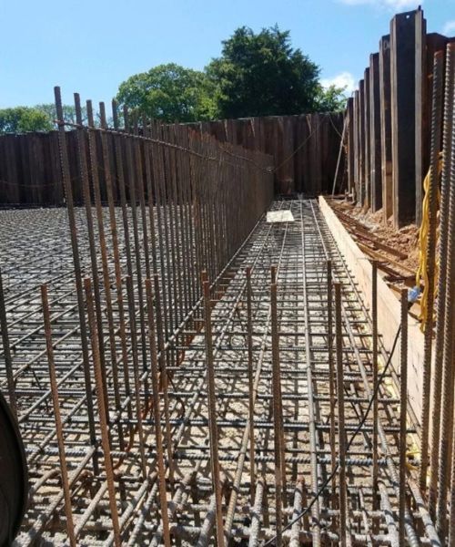 Construction site with steel rebar framework for a concrete walkway between retaining walls