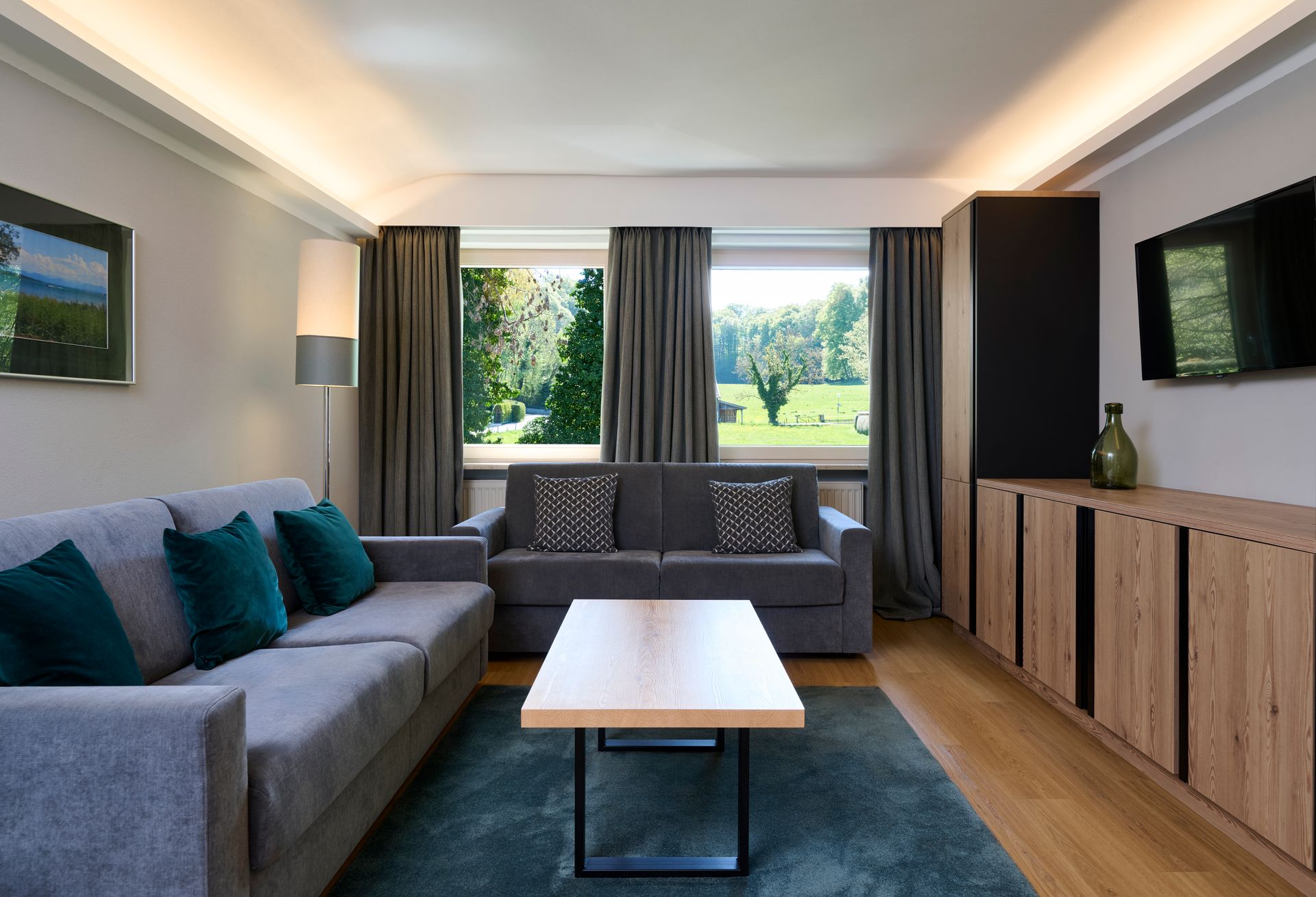 Heller Flur mit orangefarbener Wand, Spiegel, Schreibtisch unter Dachfenster und Bücherregal.