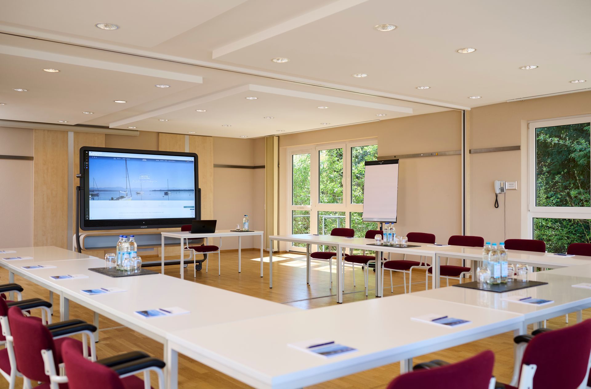 Ein Konferenzraum mit Tisch und Stühlen und vielen Fenstern