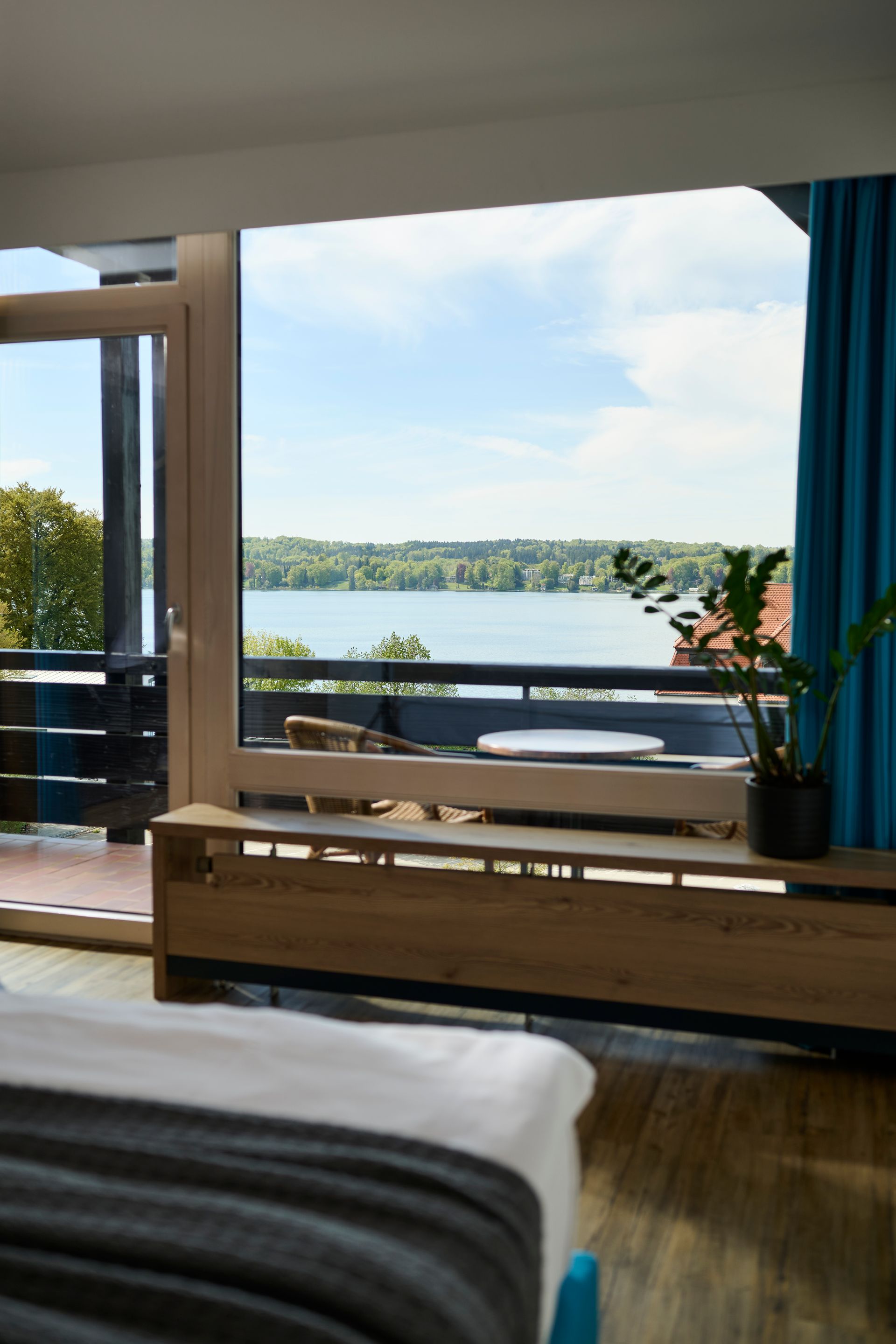 Balkon mit Tisch und Stühlen und Blick auf den Starnberger See.