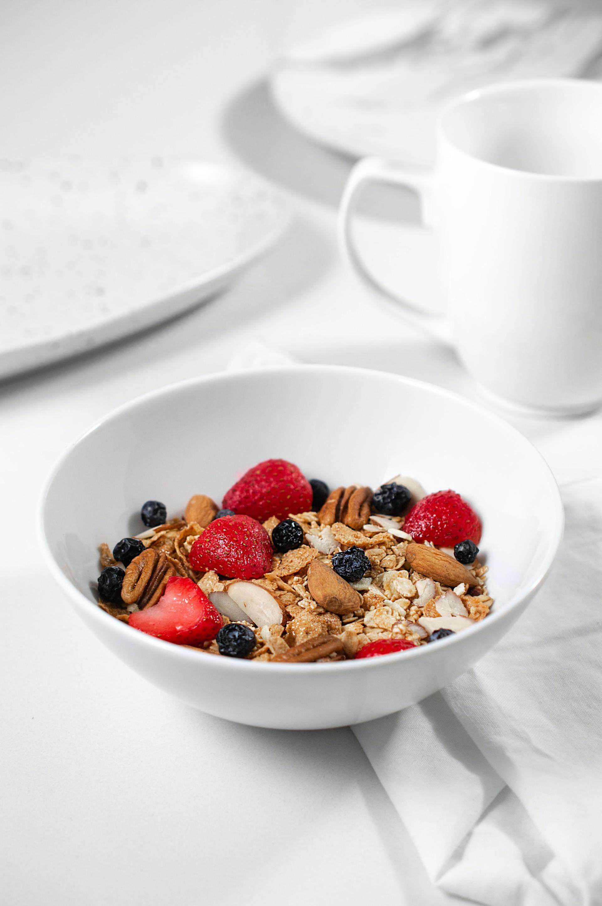Eine Schüssel Müsli mit Beeren und Joghurt auf einem Tisch.