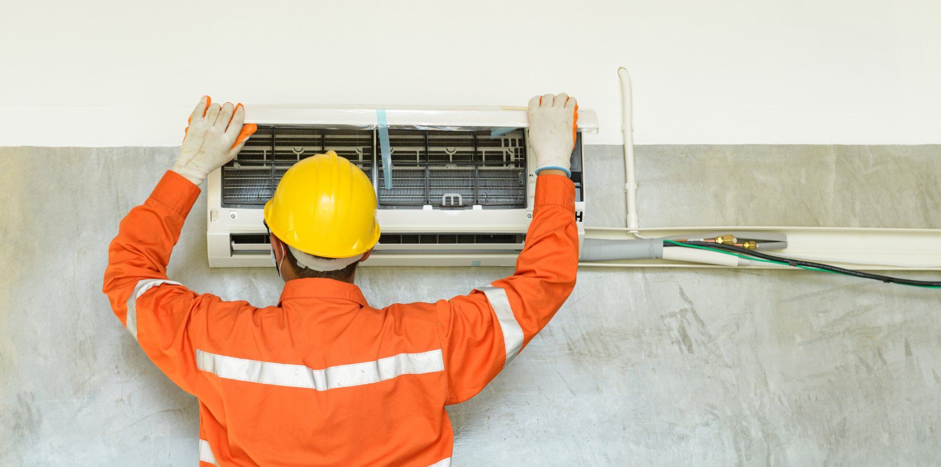 Technician Repairing Air Conditioner On The Wall — West Ivins, UT  — Airco Heating & Cooling Inc