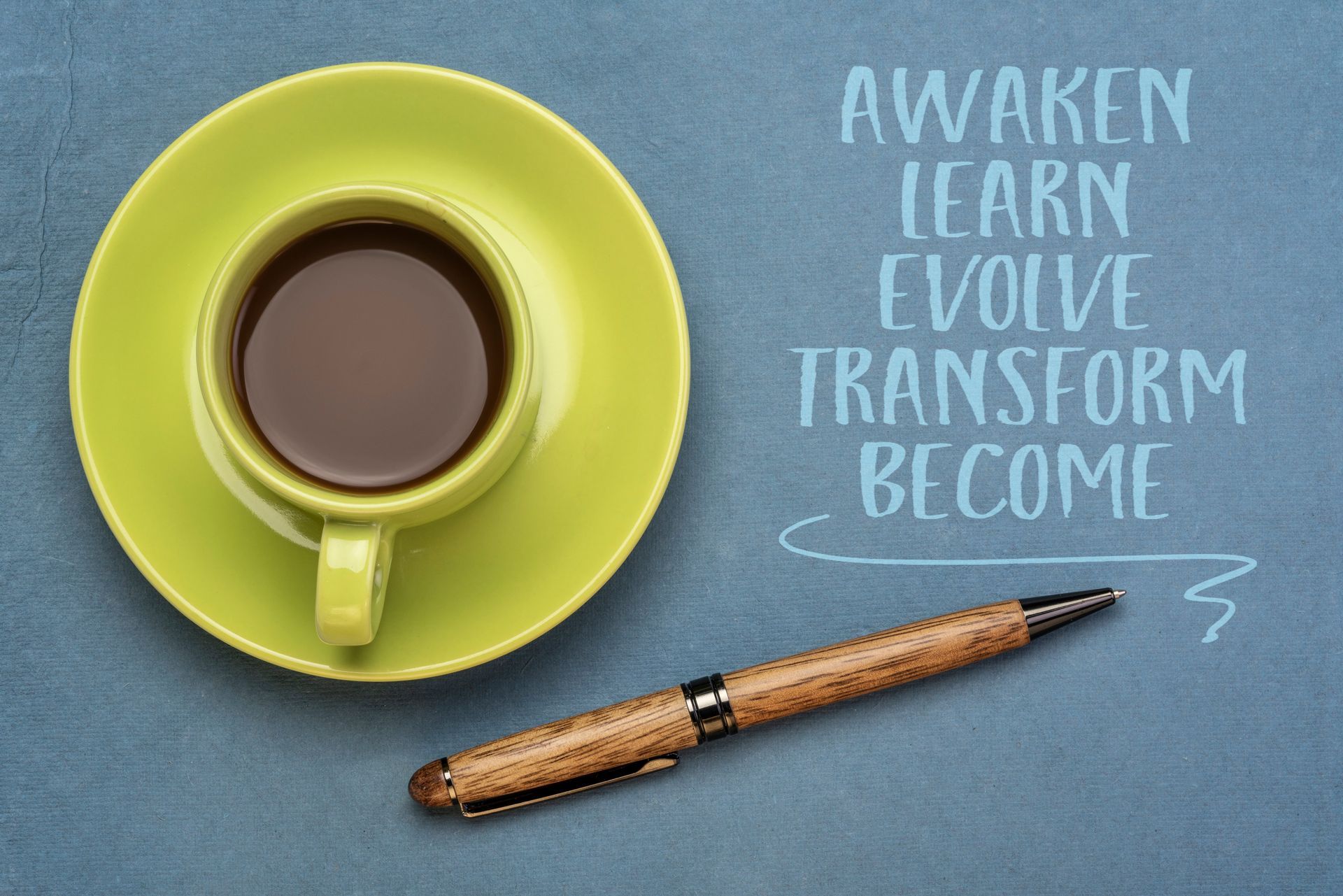 coffee cup and pen, awaken, learn evolve, transform, become