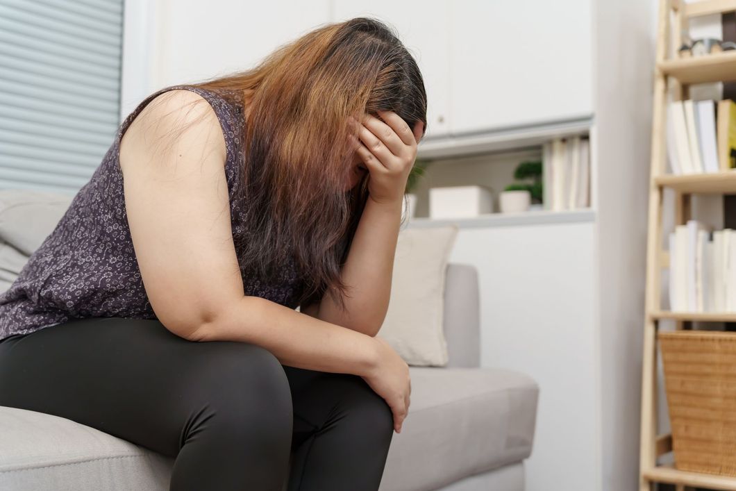 tired and upset woman holding her head, who doesn't know what to do
