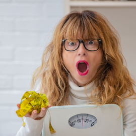 surprised woman holding a scale