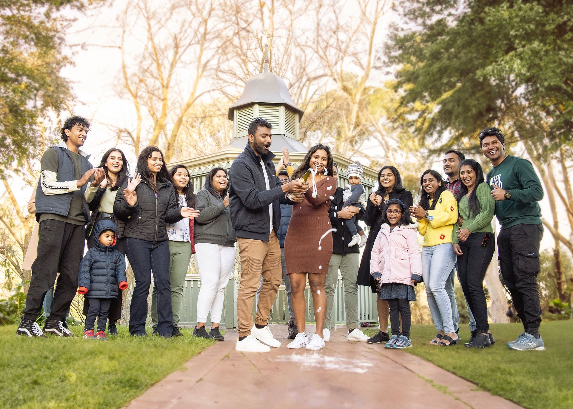 A large group of people are standing in a park.