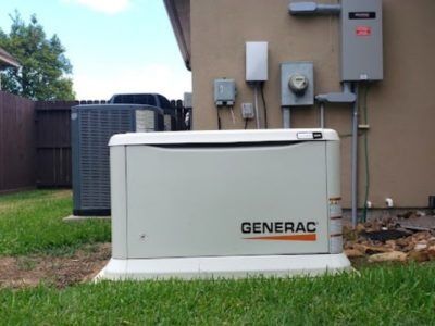 Generac home standby generator beside exterior house wall and utility meters