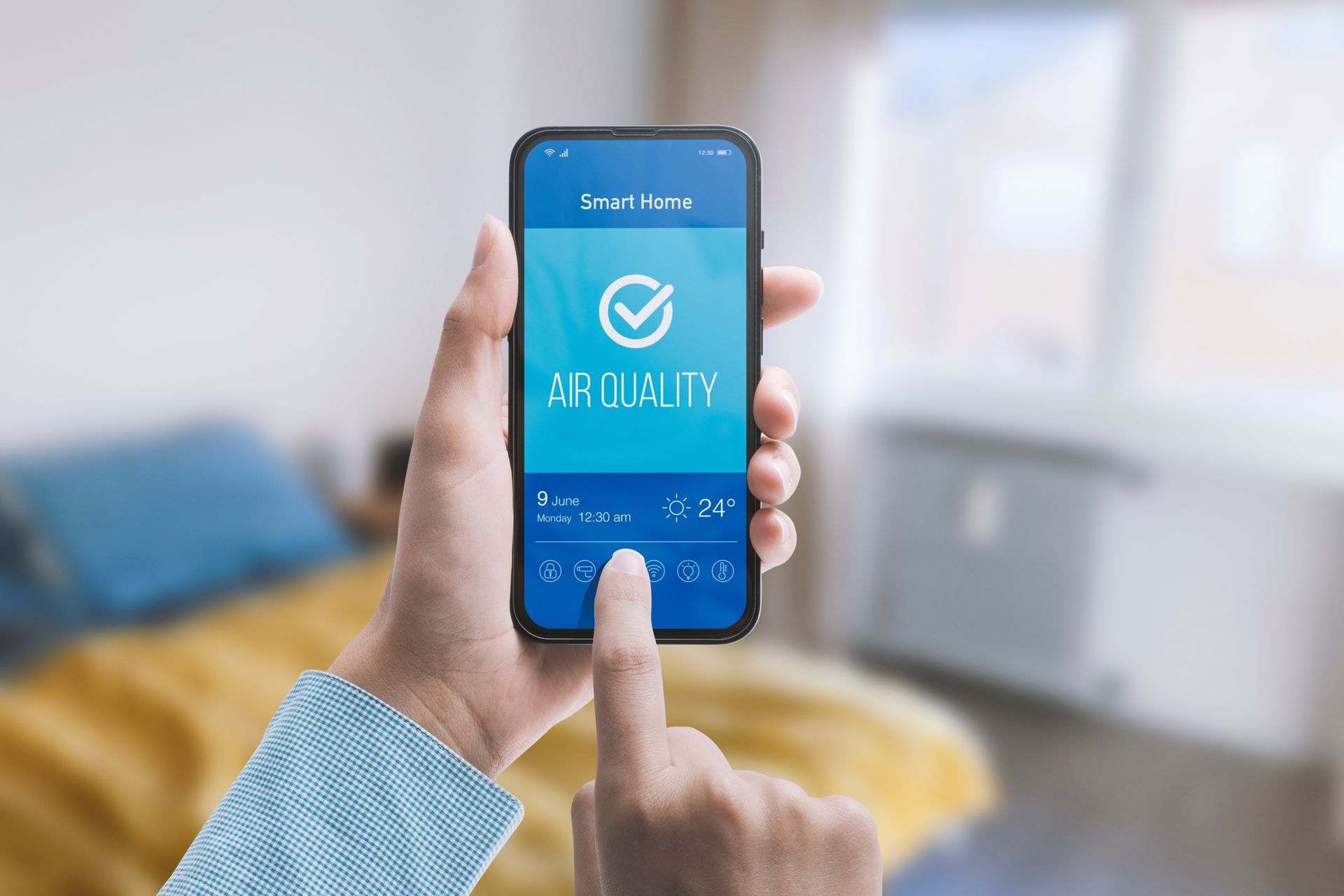 Hand holding a smartphone with a blue app screen and a finger tapping the display in a bright room