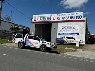 Two All Coast Hire branded trucks parked in front of their commercial building on the Gold Coast.