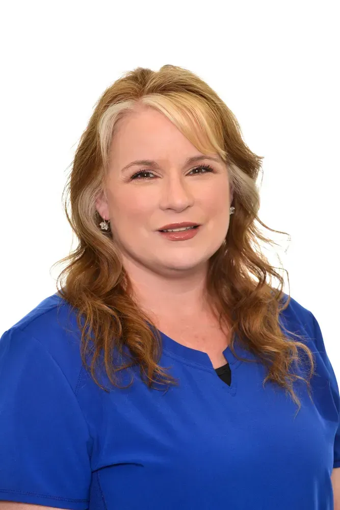 Portrait of a smiling woman in a blue blouse against a white background