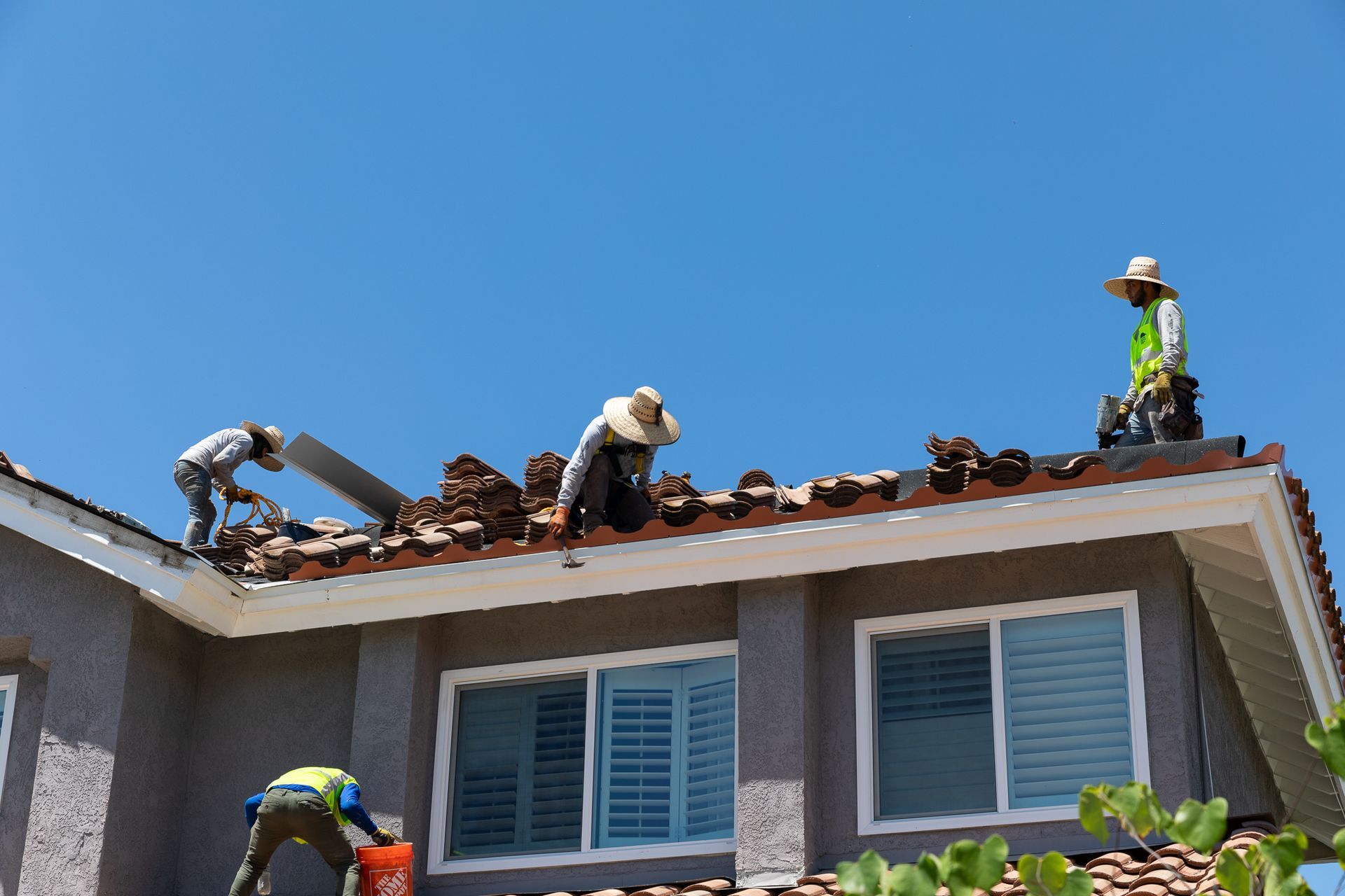 Two men are working on the roof of a house