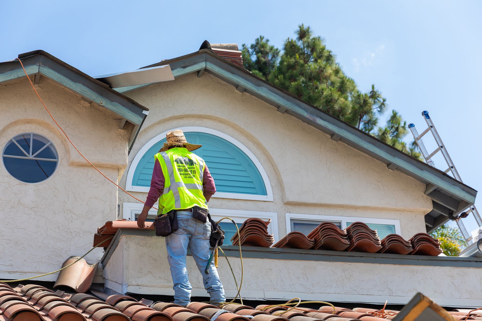 A man wearing a yellow vest that says ' roofer ' on it