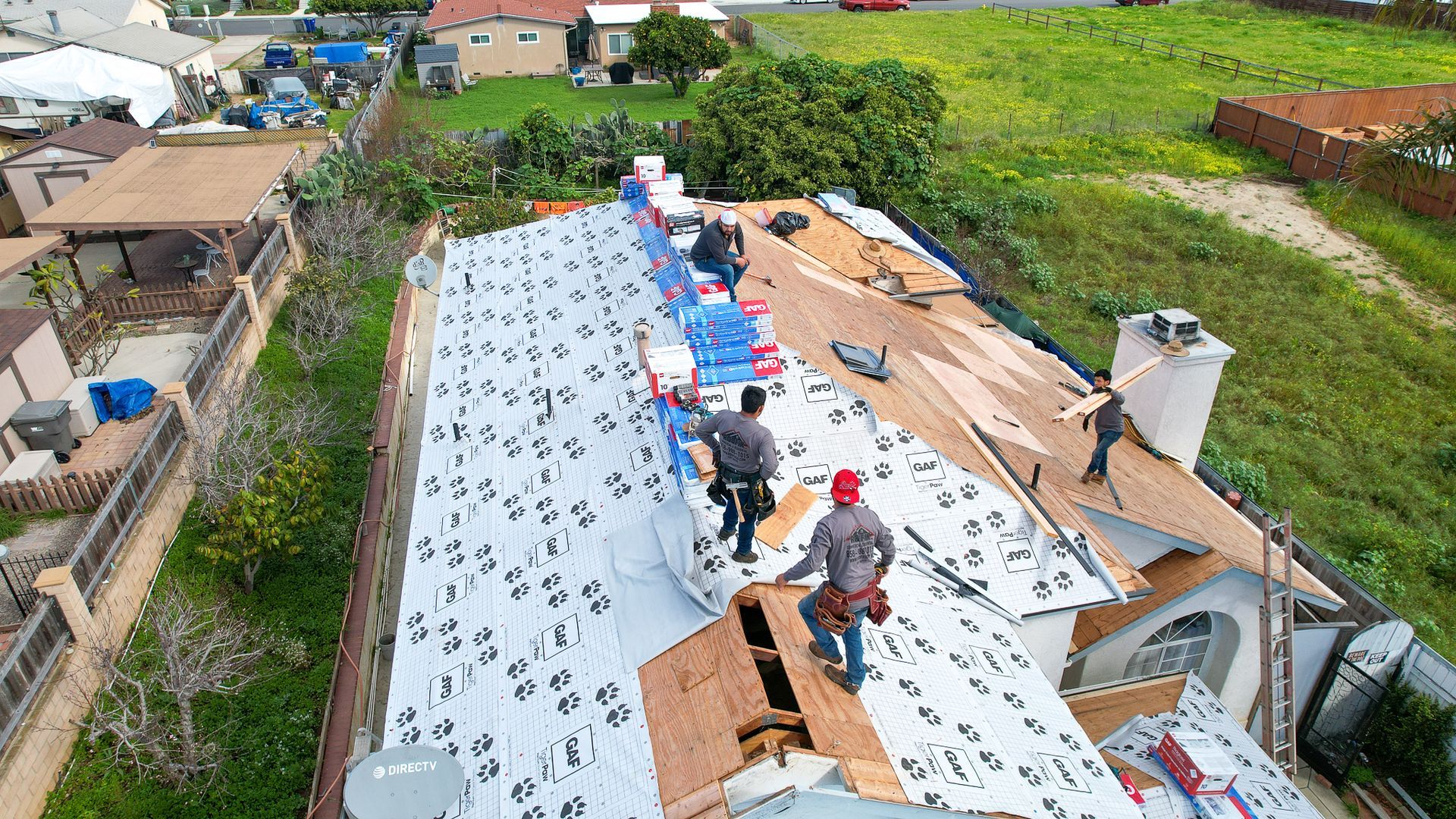 A group of men are working on the roof of a house.