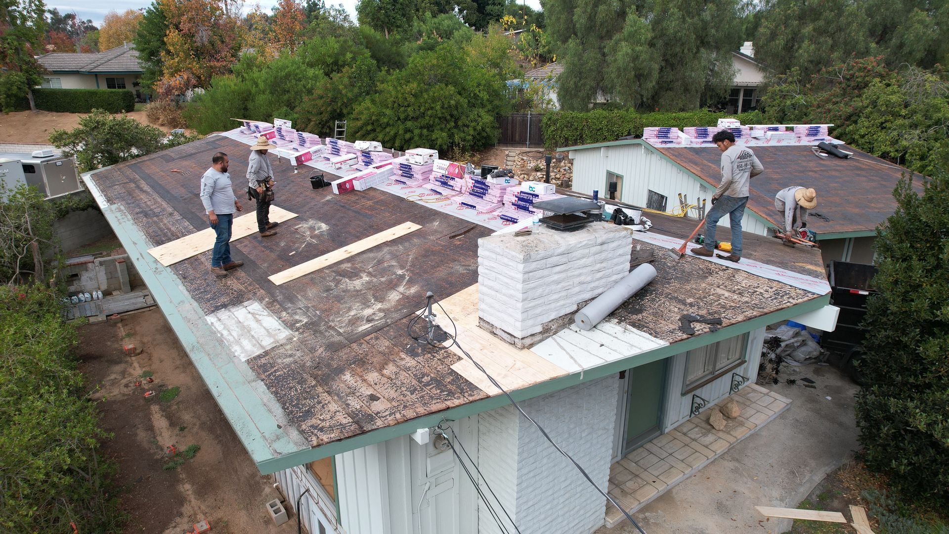 A group of men are working on the roof of a house