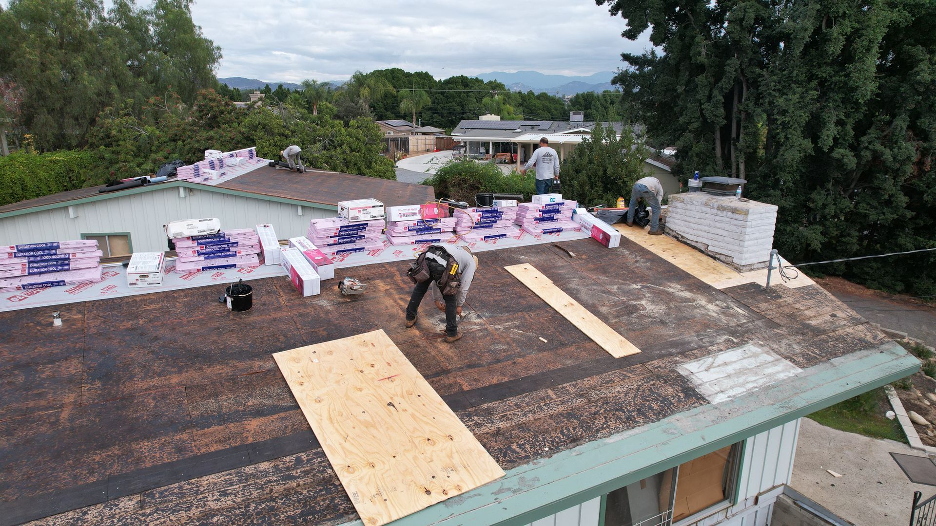 A man is working on the roof of a house