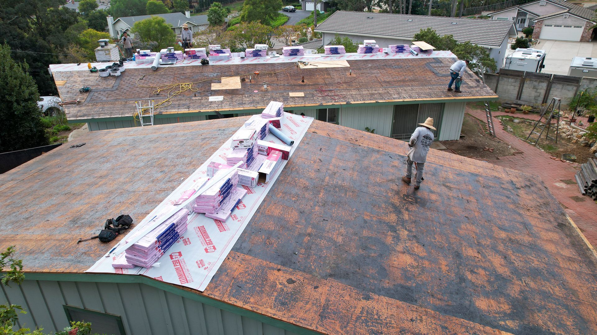 Two men are working on the roof of a building