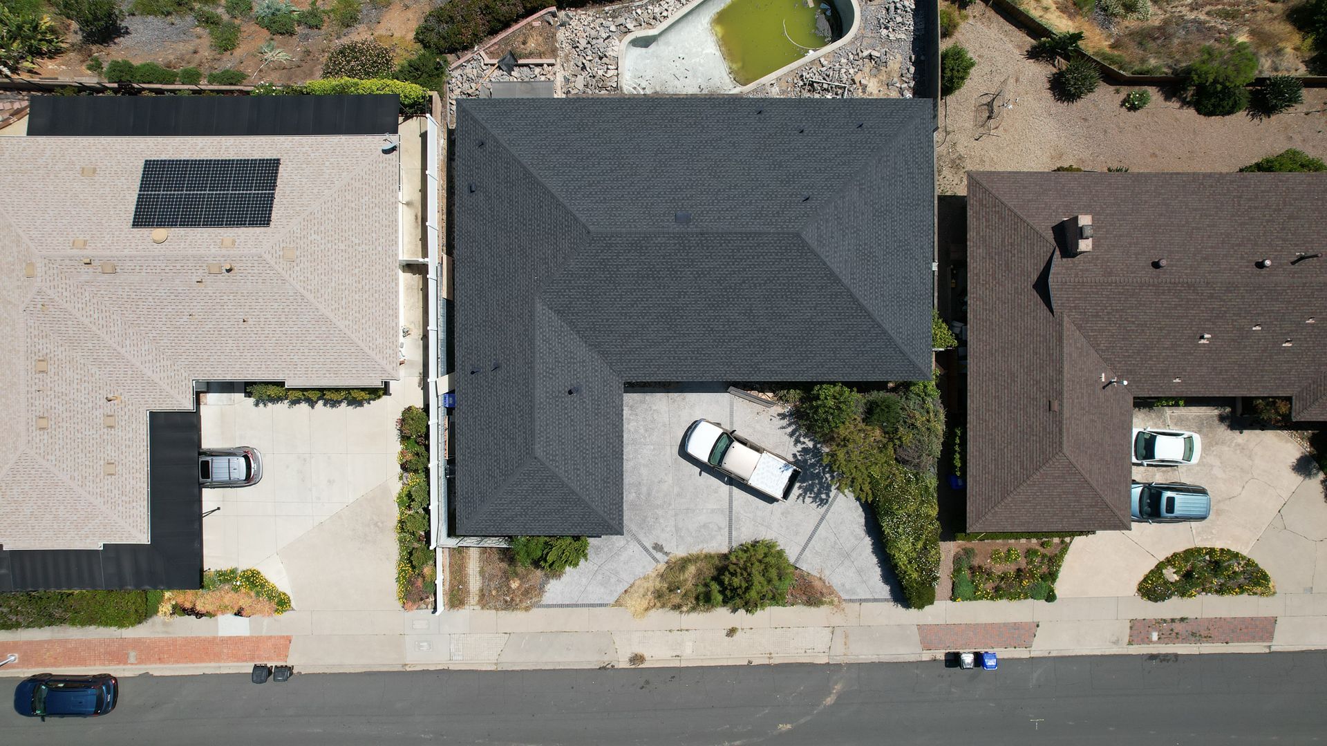 An aerial view of a house with a car parked in the driveway