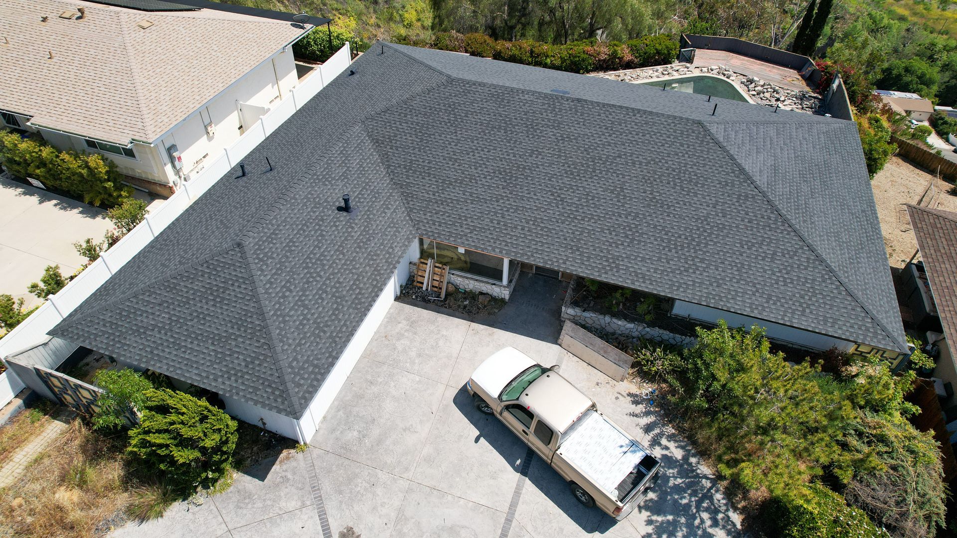 An aerial view of a house with a car parked in front of it