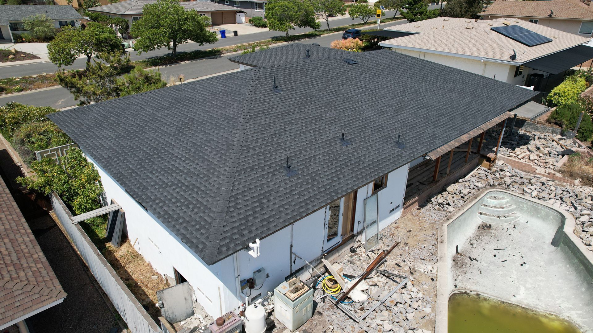 An aerial view of a house with a black roof