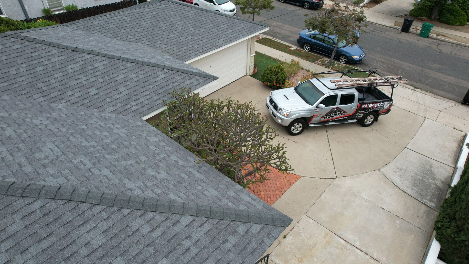 A white truck is parked in the driveway of a house