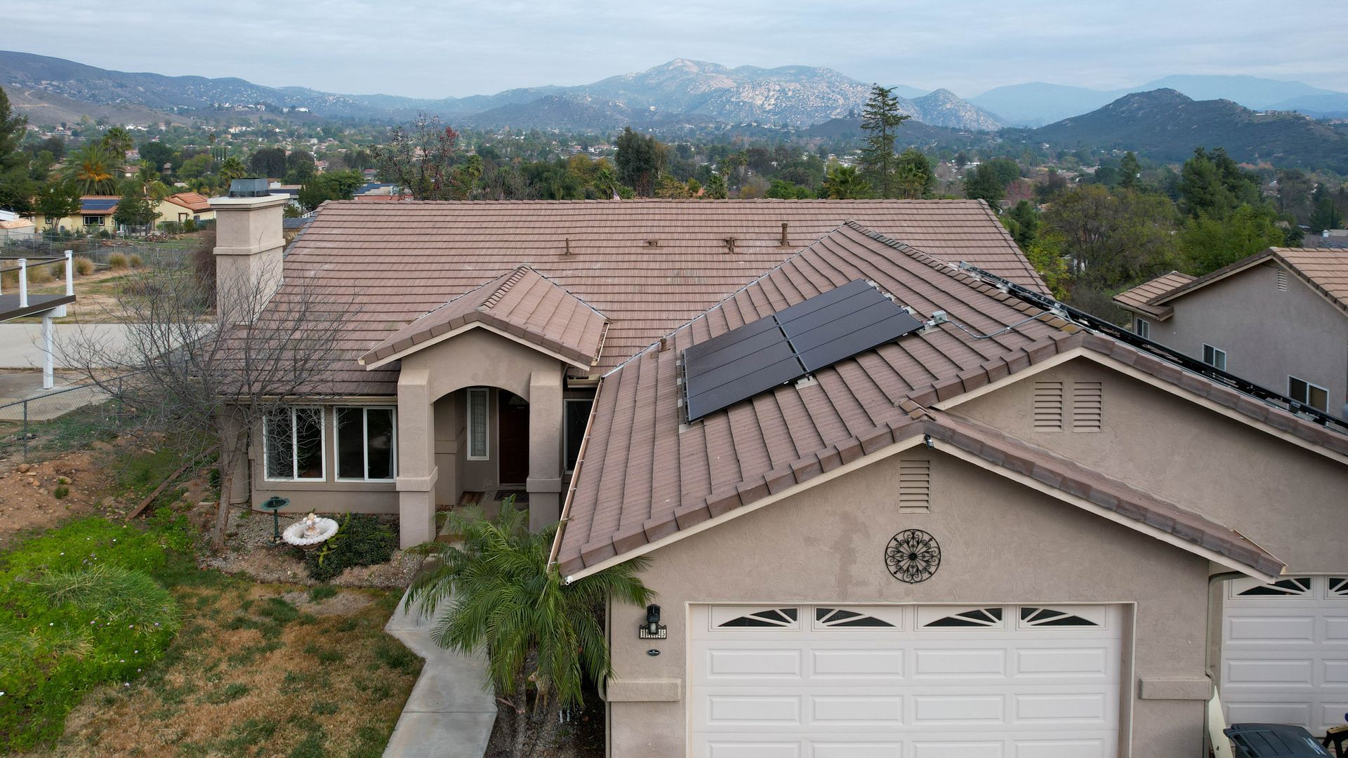 A house with solar panels on the roof with mountains in the background