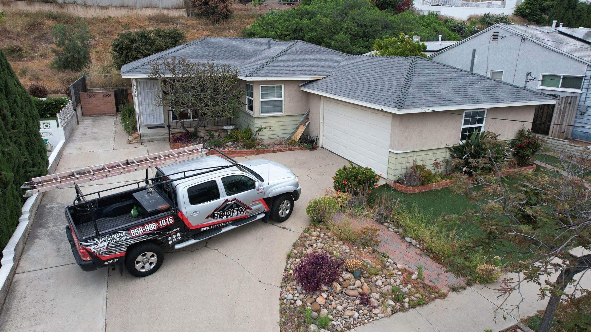 A silver truck is parked in front of a house