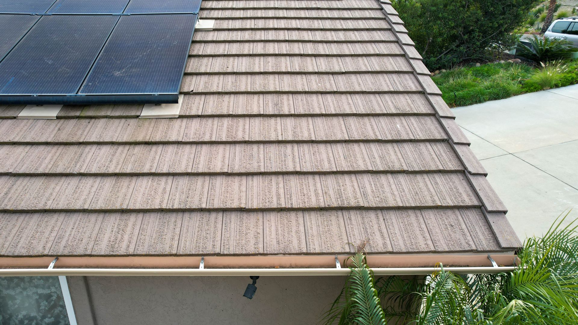 A roof with shingles and solar panels on it