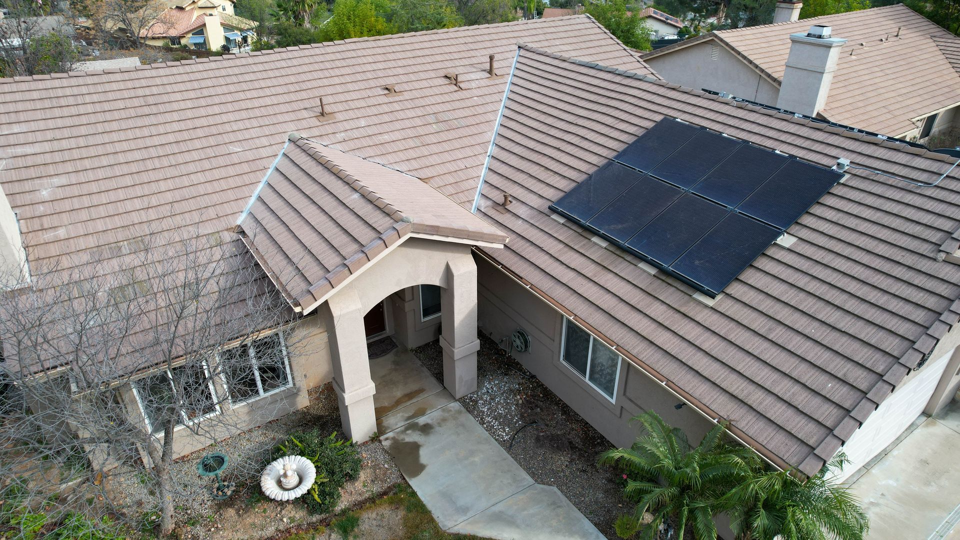 An aerial view of a house with solar panels on the roof