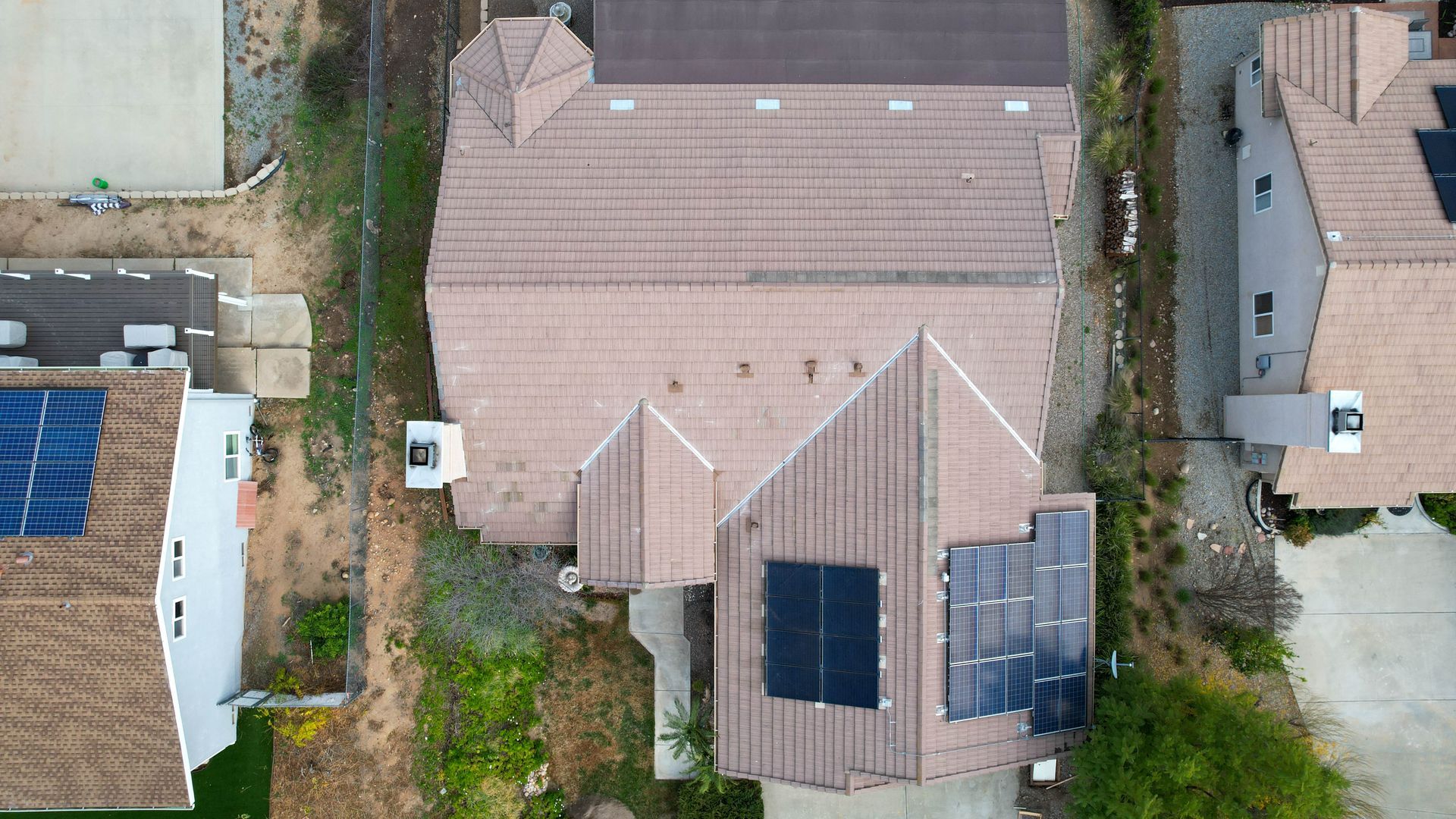 An aerial view of a house with solar panels on the roof