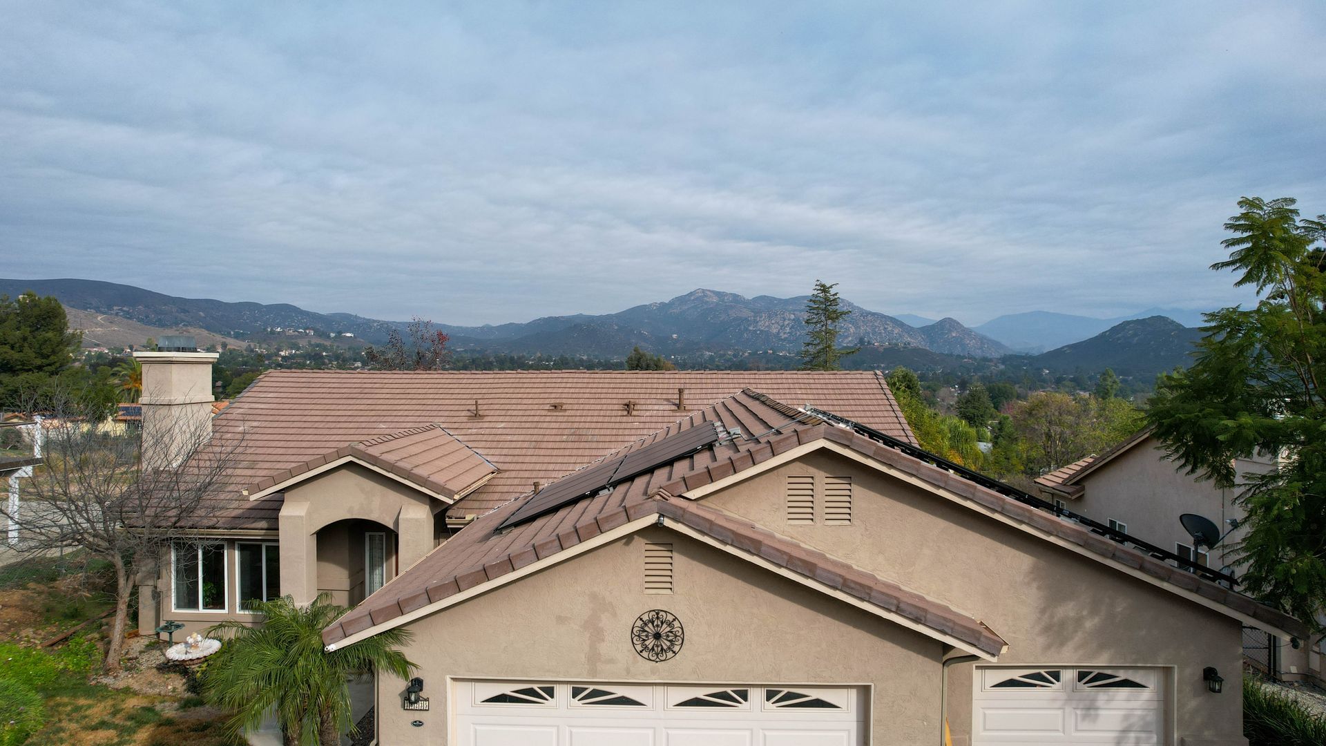 A house with two garage doors and a roof with solar panels