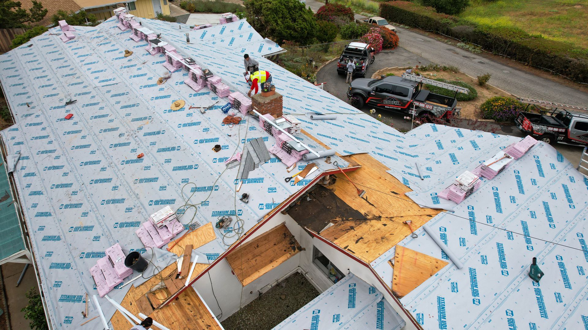 An aerial view of a house with a roof that is being remodeled