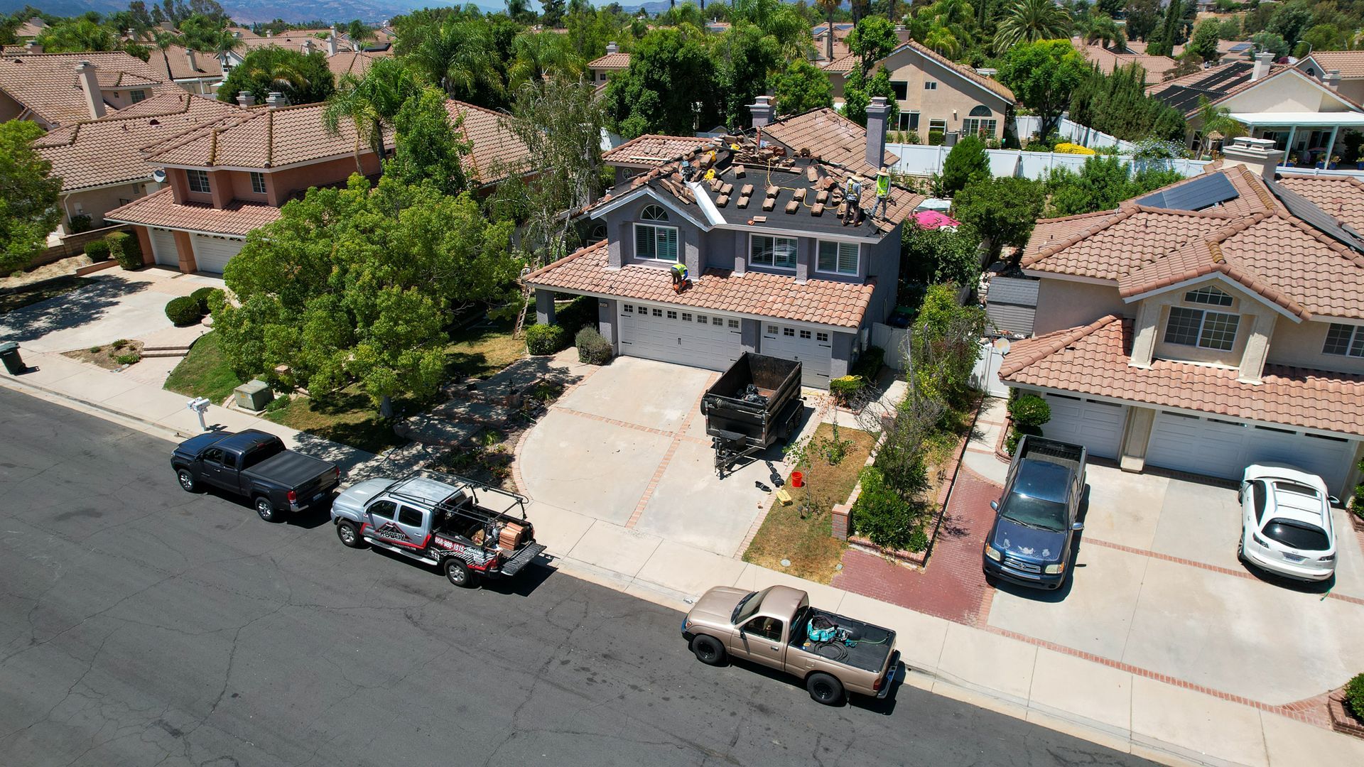 A row of cars are parked in front of a house