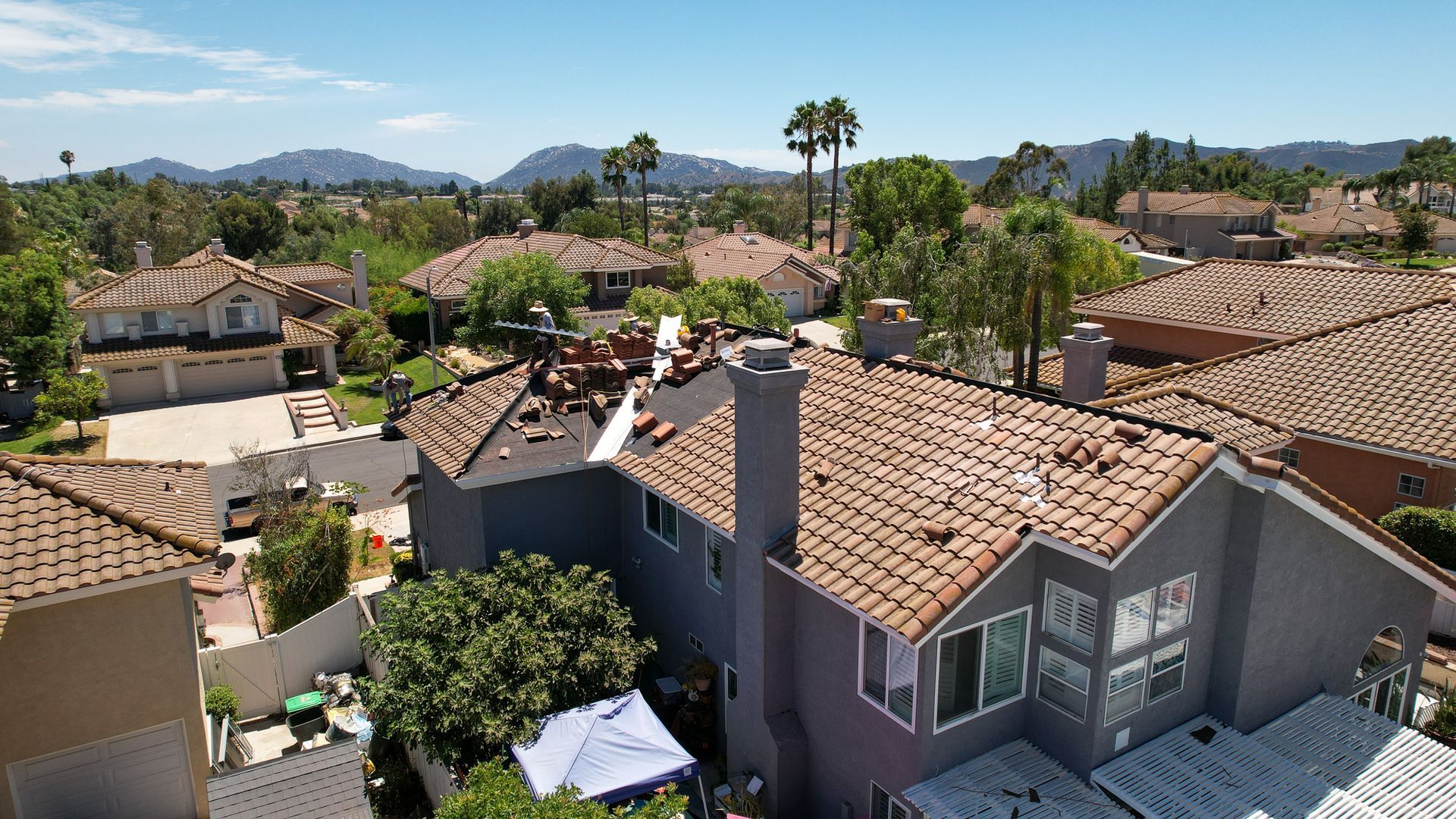 An aerial view of a residential area with a house in the foreground