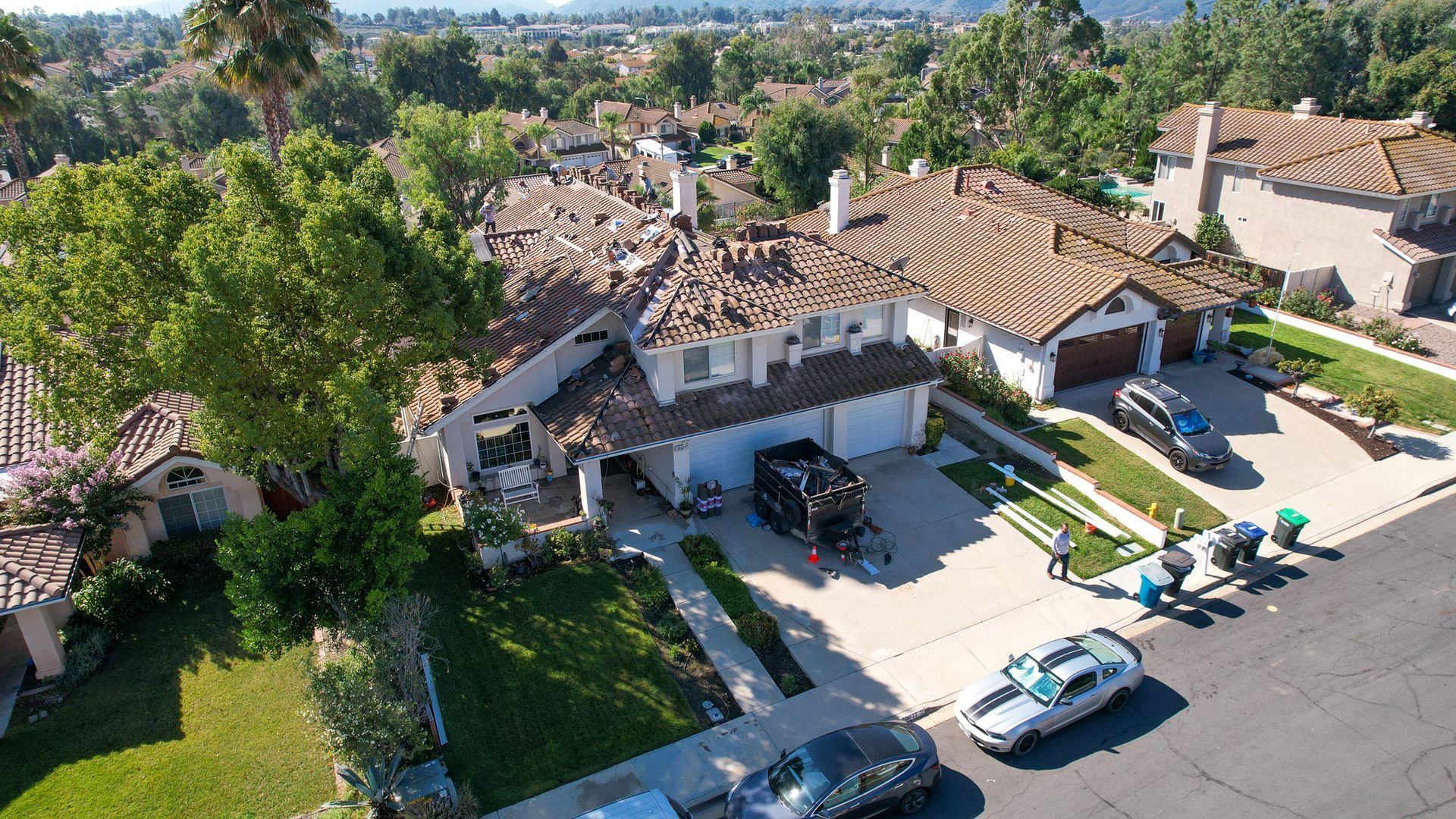 An aerial view of a residential neighborhood with cars parked in front of houses
