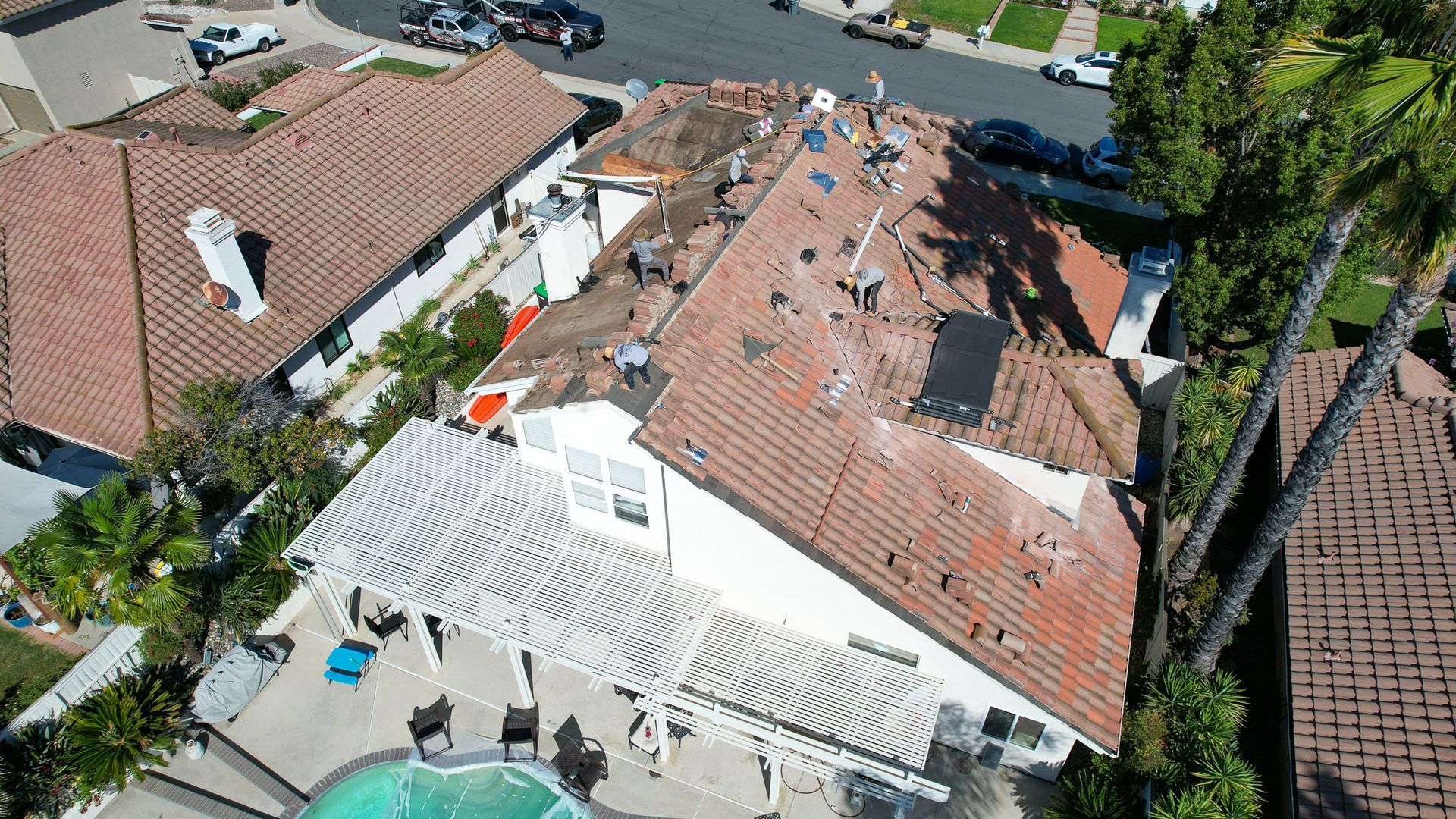 An aerial view of a house with a pool in front of it