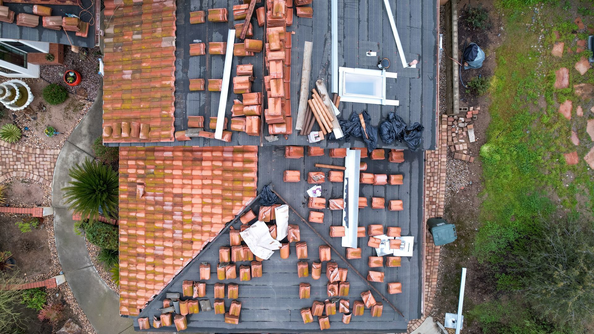 An aerial view of a house with a roof that is being repaired.