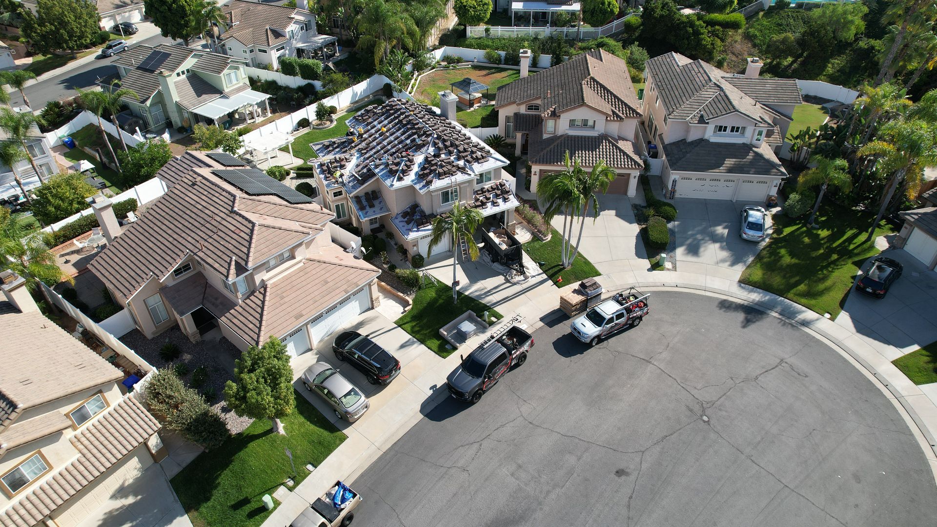 An aerial view of a residential neighborhood with cars parked on the street