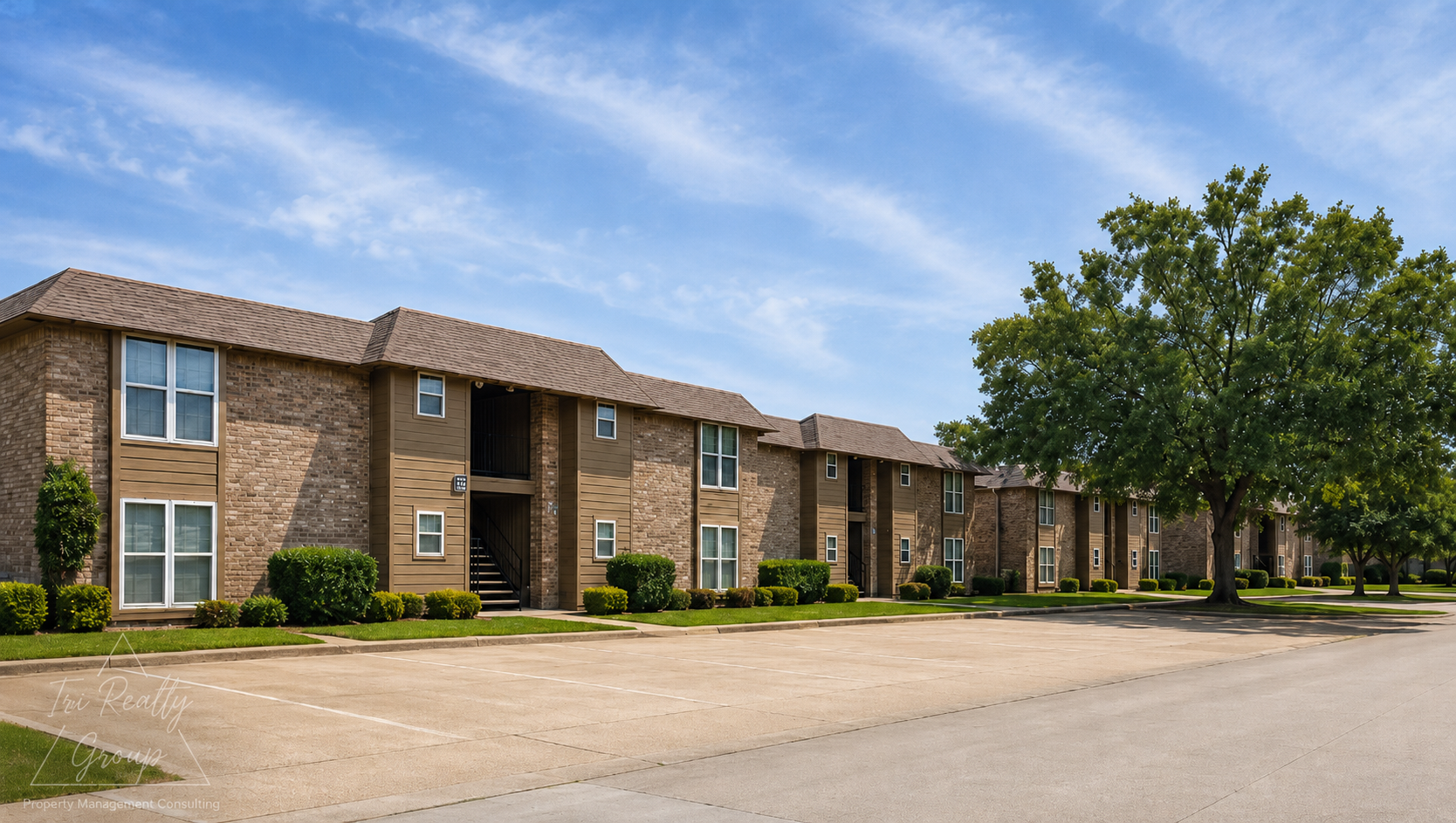 Two-story brick apartment building along a quiet street under a blue sky