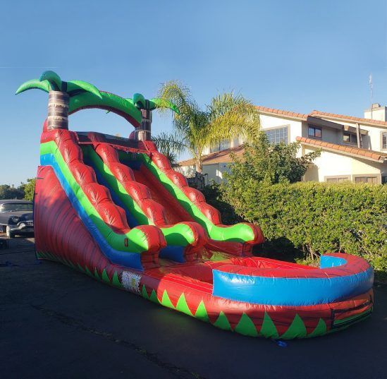 Colorful inflatable water slide with red, green, and blue lanes in a driveway outdoors