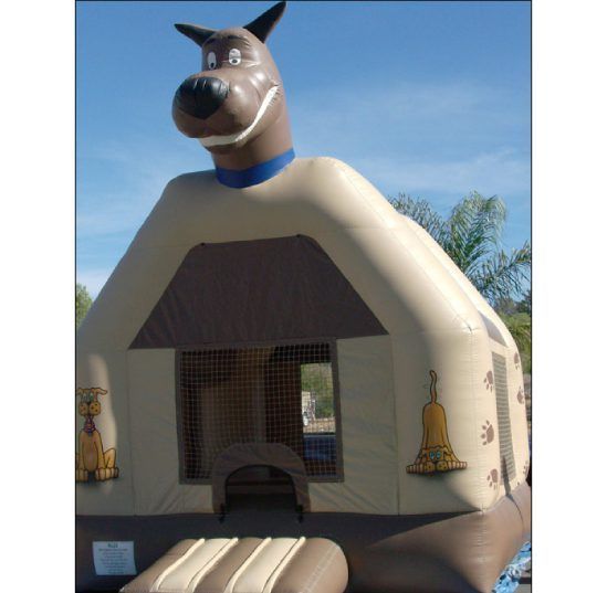 Inflatable dog bounce house with tan walls and blue collar under a clear sky
