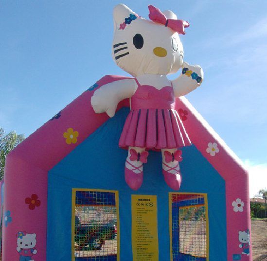 Giant Hello Kitty inflatable on a pink-and-blue playhouse under a clear sky